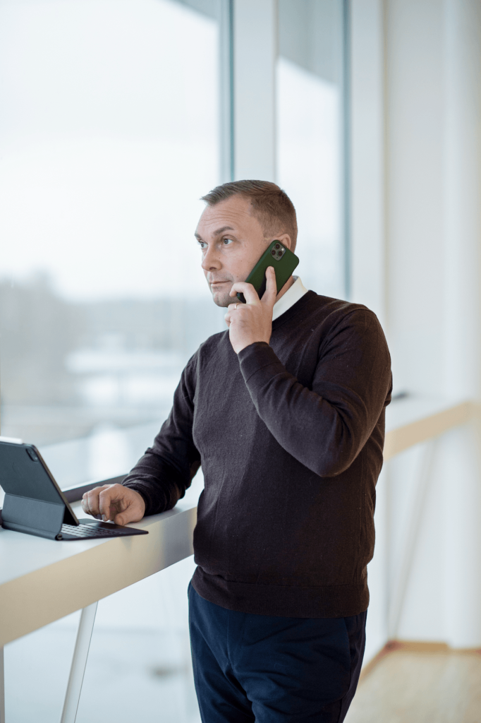 Telefonsamtal stående vid ett högt bord