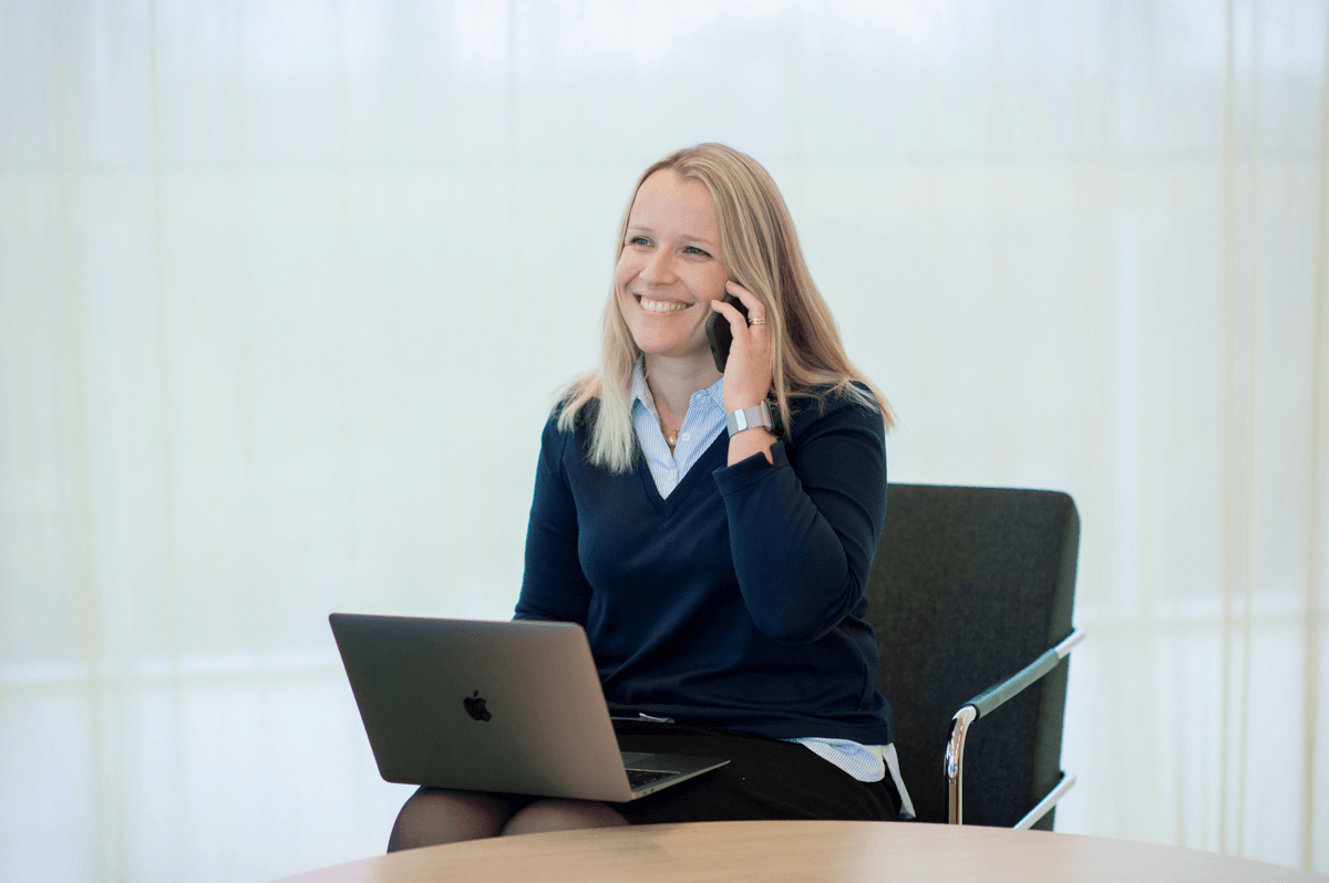 Telefonsamtal med laptop i knät